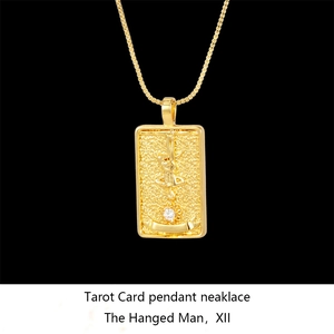 Detailed close-up of gold Solomon Tarot pendant featuring The Hanged Man with crystal stone