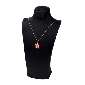 Dettaglio della collana dorata con ciondolo a cuore a raggiera e pietre di cristallo