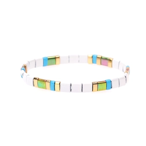 Dettaglio del bracciale elastico in perle Tila con tessere di smalto colorate in blu e oro