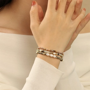 Detail van een drielaagse armbandset met zoetwaterparels en groene natuursteen