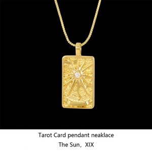 Macro shot of gold tarot sun pendant necklace with sparkling crystal inlay on black background