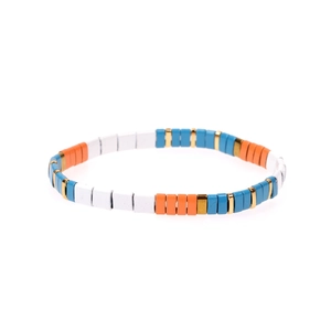Dettaglio macro del braccialetto elastico in perline Tila smaltate blu, arancione e bianco