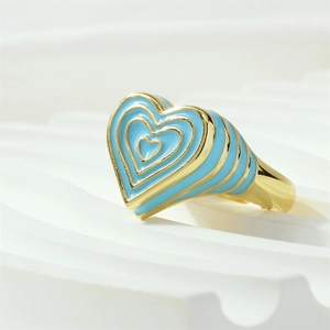 Détail macro d'une bague coeur plaquée or avec émail bleu clair et texture rayée