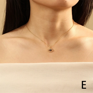 Golden Evil Eye necklace with blue stone and crystals worn by a model in warm light