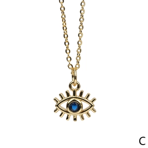 Detail shot of the evil eye pendant necklace in gold with blue center stone
