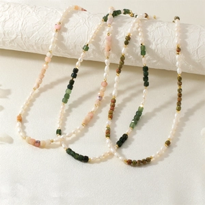 Detail of beaded necklace with freshwater pearls and green pink gemstones on silk