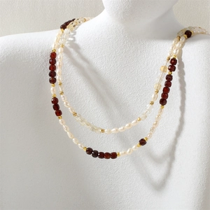 Detail view of triple-layered necklace with freshwater pearls and faceted gemstones