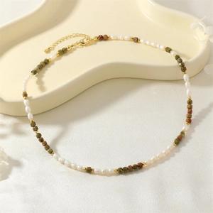 Detail of vintage necklace with freshwater pearls, colorful natural stones and golden clasp