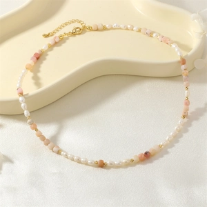 Detailed shot of vintage pearl and pink stone necklace with gold lobster clasp