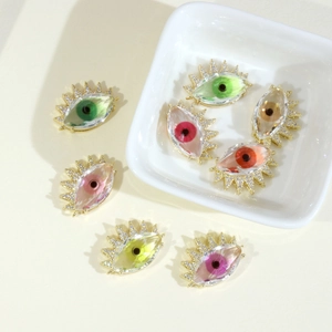 Macro detail of colorful evil eye crystal pendants with pavé set crystals and gold plating