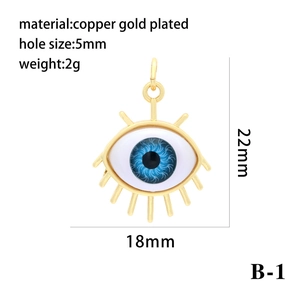 Macro detail of 18K gold-plated Evil Eye resin pendant with eyelashes and dimensions