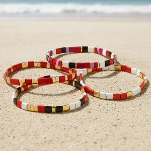 Bohemian colorful enamel bead stretch bracelets on a sandy beach with ocean background