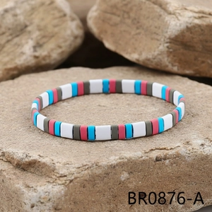 Close-up of rainbow enamel tile elastic bracelet on natural stone background