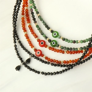 Detail of colorful Evil Eye handmade beaded necklaces with mixed gemstones and gold spacers