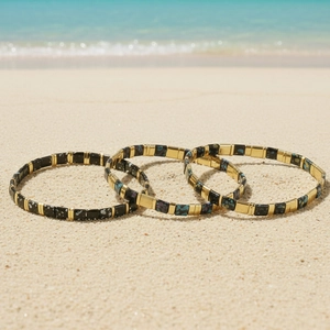 Bohemian colorful painted copper tila bead stretch bracelets on a sunny beach background