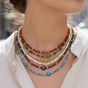 Colorful set of six stacked beaded necklaces with evil eye pendants and gold metal spacers