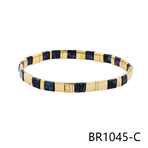Detail of bohemian Tila bracelet with gold metal plates and purple-blue enamel beads