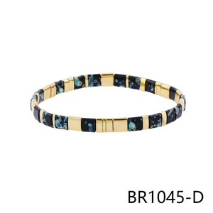 Detail of Bohemian stretch bracelet with gold cubes and black enamel splatter painted beads