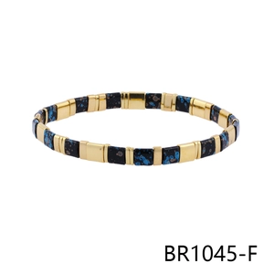 Detail view of Bohemian tile bead bracelet with black and blue ink splatters and gold spacers