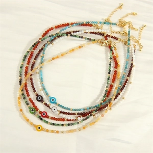 Colorful evil eye beaded necklace with gold accents and faceted glass stones on white silk