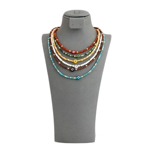 Detailed set of six bohemian beaded necklaces with colorful Evil Eye charms on grey display