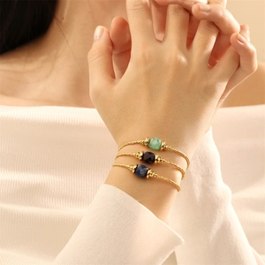 Nahaufnahme eleganter 18K vergoldeter Perlenarmbänder mit Lapislazuli und Amethyst-Steinen