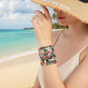 Close-up of bohemian rainbow Tila bead elastic bracelets set on beach vacation