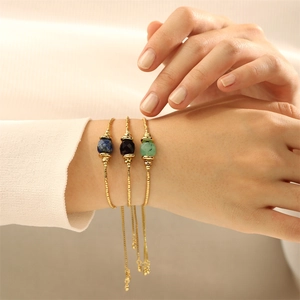 Nahaufnahme von drei 18K vergoldeten Armbändern mit verstellbaren Ketten und Edelsteinen
