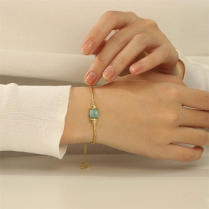 Detailaufnahme des 18K vergoldeten verstellbaren Armbands mit grünem facettierten Stein