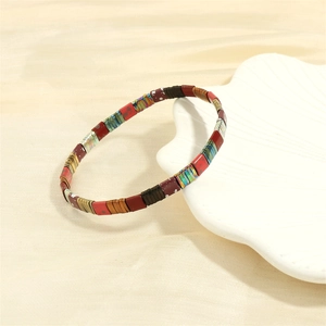 Detailed view of colorful Tila bead bracelet displayed on a white shell ceramic tray