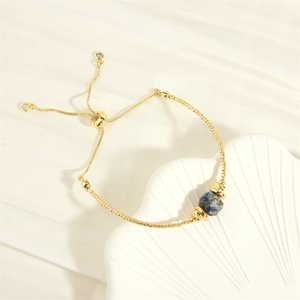 Detail eines verstellbaren vergoldeten Armbands mit blauer Lapislazuli-Marmorkugel