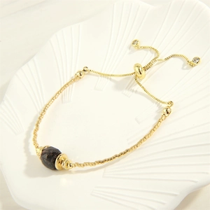 Detail eines verstellbaren 18K vergoldeten Armbands mit facettiertem braunem Edelstein