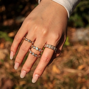 Macro shot of four assorted gold plated stainless steel rings with clear zircon crystals