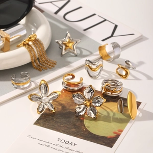 Detailed close-up of mixed metal rings and pearl flower earrings in a chic fashion setting