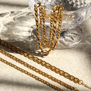 Détail de chaînes Figaro en acier inoxydable plaqué or 18K avec reflets de cristal