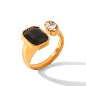 Dettaglio anello dorato con pietra nera geometrica e accenti in zircone chiaro