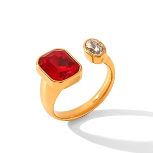 Dettaglio dell'anello aperto dorato con pietra rossa rettangolare e zircone trasparente