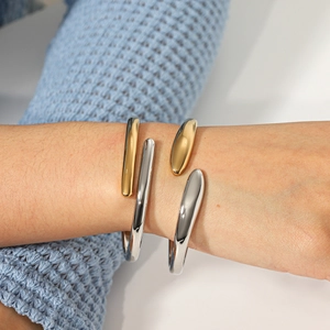 Modern stainless steel irregular water drop bangles in gold and silver finish on wrist