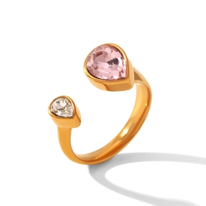Dettaglio dell'anello dorato con pietre di zirconia a goccia in rosa e bianco lucido