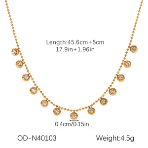 Détail du collier à billes dorées avec pendentifs zircons et mesures sur fond blanc