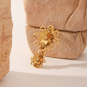 Détail de pince à cheveux fleur en or 18k avec zircons sur texture pierre naturelle