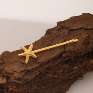 Barrette étoile de mer élégante en acier inoxydable doré 18 carats sur fond d'écorce