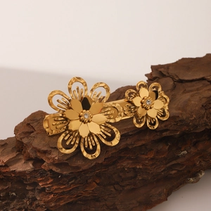 Détail macro d'une pince à cheveux fleur dorée avec zircons sur fond d'écorce rustique