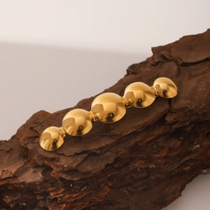 Dettaglio del fermaglio per capelli in oro 18 carats su sfondo in corteccia scura