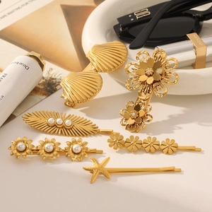 Détails de pinces à cheveux dorées avec perles, coquillages et motifs floraux