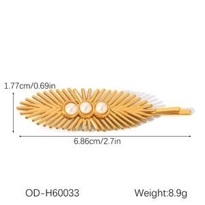 Vue détaillée d'une barrette dorée 18 carats au motif rayon de soleil et trois perles blanches