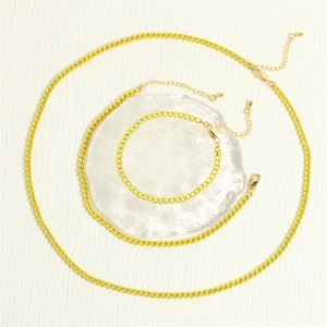 Three-piece layered yellow Cuban link necklace set with modern minimalist metal finish