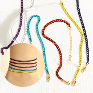 Detail view of colorful Cuban link anklets with adjustable gold lobster clasp closures