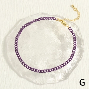 Detailed macro view of purple lacquered Cuban link anklet with adjustable gold clasp