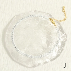 Detail of chunky white matte link chain with gold lobster clasp and extension chain